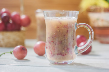 Grape smoothie over the white table.