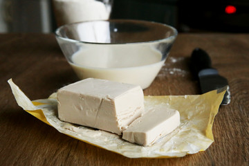 Fresh yeast block and milk for baking. Preparation process of making dough.