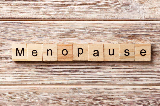 menopause word written on wood block. menopause text on table, concept