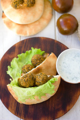 Top view of falafel with vegetables and pita bread.