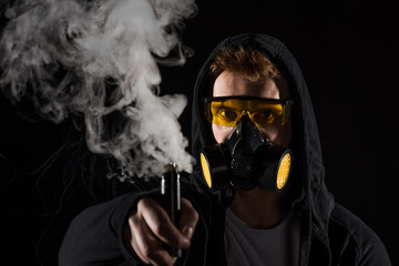 Man wearing protective filter mask activating electronic cigarette
