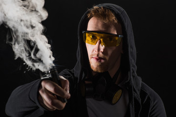 Man wearing protective filter mask activating electronic cigarette