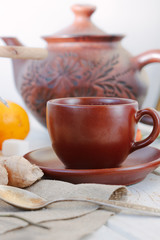 Nice ginger tea on white wooden surface.