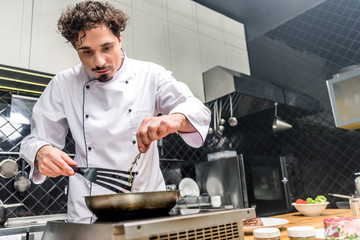 chef adding thyme twig on frying pan