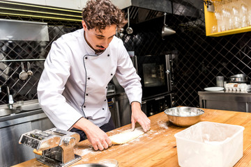 chef preparing dough for pasta on table
