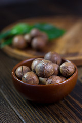 Macadamia nuts in a brown ceramic bowl.