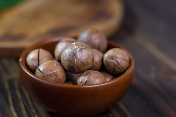 Macadamia nuts in a brown ceramic bowl.