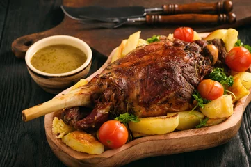 Gardinen Slow baked lamb leg with potatoes and sauce. © O.B.