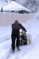 Man working with a snow blowing machine v