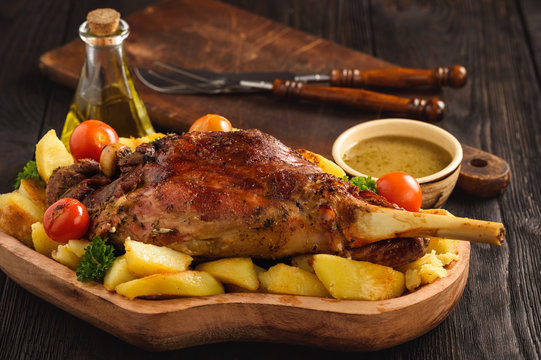 Slow baked lamb leg with potatoes and sauce.