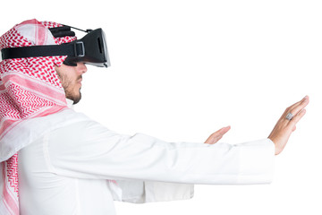 Young muslim guy trying VR glasses. Isolated.