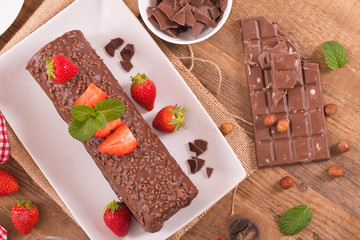 Chocolate roll with hazelnuts and strawberries. 