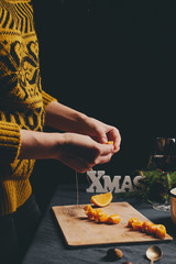 Female hands cooking orange jam for Christmas gifts
