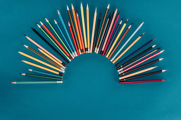 Top view of composition of colorful pencils isolated on blue background