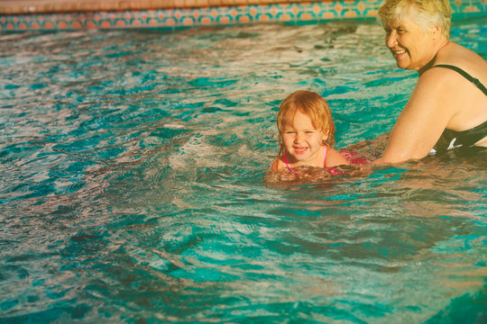 grandmother teaching little granddaughter to swim