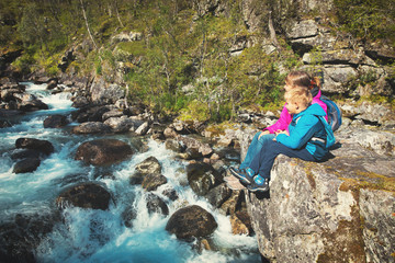 Naklejka na ściany i meble mother and son looking at waterfall, travel in Norway