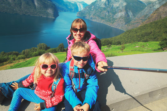 mother with kids travel in mountains of Norway, making selfie
