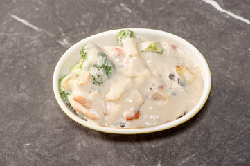 stewed chicken and rice in cream on gray table
