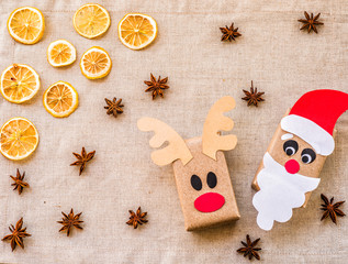 two gift boxes from recycled paper on linen background with lemon and spices. ecological christmas