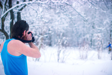 Naked man make some photo in the winter snowy forest