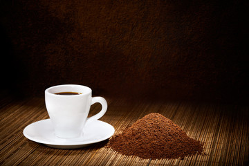 Cup of espresso ground coffee on dark background