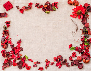 linen table cloth with dry red flowers and herbs. floral background