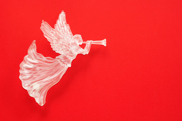 Christmas angel figurine on red background.