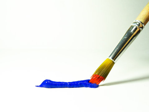 A strip of blue paint and a brush with red paint.