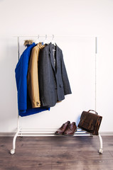 Outer clothing on the shoulders on the dressing counter. Shoes and bags on the floor. On a white background. © olgaarkhipenko