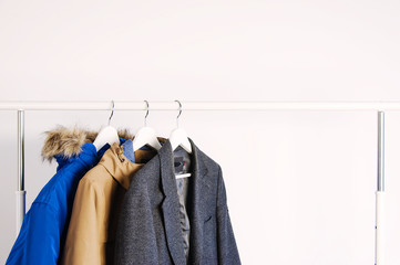 Outer clothing on the shoulders on the dressing counter. Shoes and bags on the floor. On a white background. © olgaarkhipenko