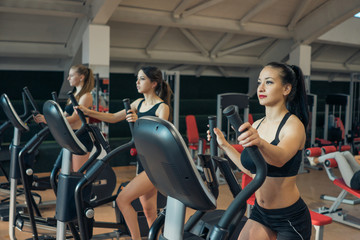 Obraz na płótnie Canvas Young girls who train on a treadmill in the gym