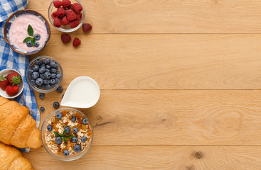 Continental breakfast with croissants and berries on natural wood