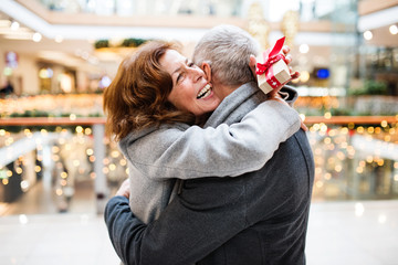 Senior couple with present doing Christmas shopping.