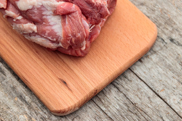 Raw pork meat on cutting board on a table