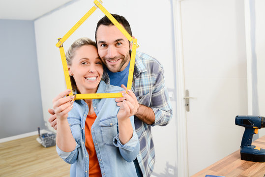 cheerful young couple making future project and renovating new home