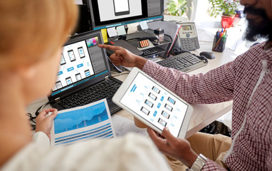 designers with interface on laptop and tablet pc