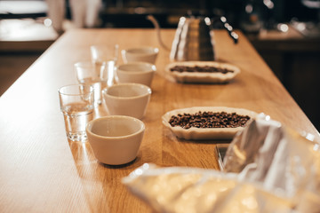 Fototapeta na wymiar close up view of arranged bowls with coffee beans and grind coffee for food function on wooden tabletop