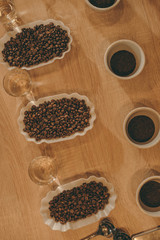 top view of arrangement of bowls with coffee beans and glasses of water for food function on wooden tabletop