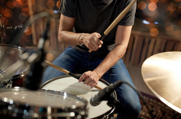 male musician playing drum kit at concert