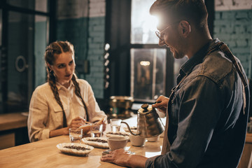 man pouring hot water into bowl with grind coffee during coffee food function at coffee shop