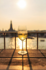 View of Chao Phraya River and Wat Arun background on sunset from bar&restaurant with glasses of wine, Bangkok, Thailand