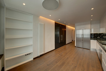A drawing room white with a wooden floor and the big refrigerator
