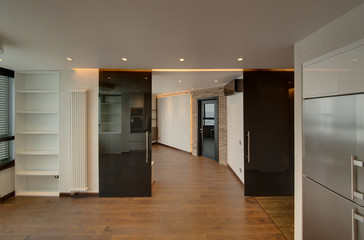 The kitchen divided from a drawing room by big black glass doors