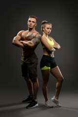 Sexy young fitness couple shot on gray background