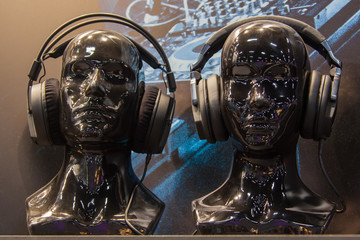 Black glossy mannequin heads in modern headphones
