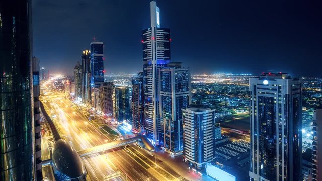 Spectacular nighttime skyline of Dubai. UAE. Aerial view of skyscrapers, highways and metro station. 4K time lapse. Colourful travel background.