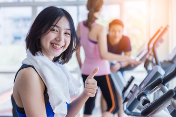 beautiful Asian fitness teenager on bicycle machine doing spinning at fitness. sport and Healthy concept. Workout with happiness and Cardio ideas.