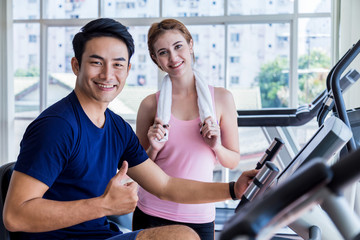 Fototapeta na wymiar Health and sport concept . Shot of friends young girls and smart man exercising happiness together in the gym using bicycle and treadmill