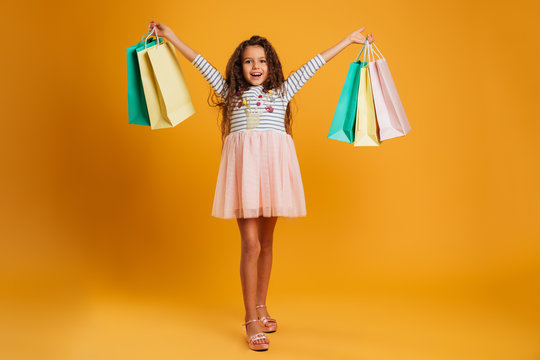 Cheerful Girl Child Holding Shopping Bags.