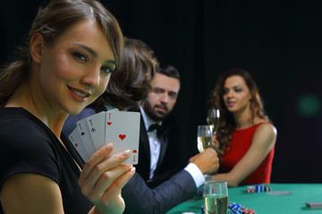 Fototapeta premium Portrait of the female gambler at the poker table with cards